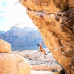 Mixed Race Girl Rock Climbing And Falling From Cliff Stock Photo