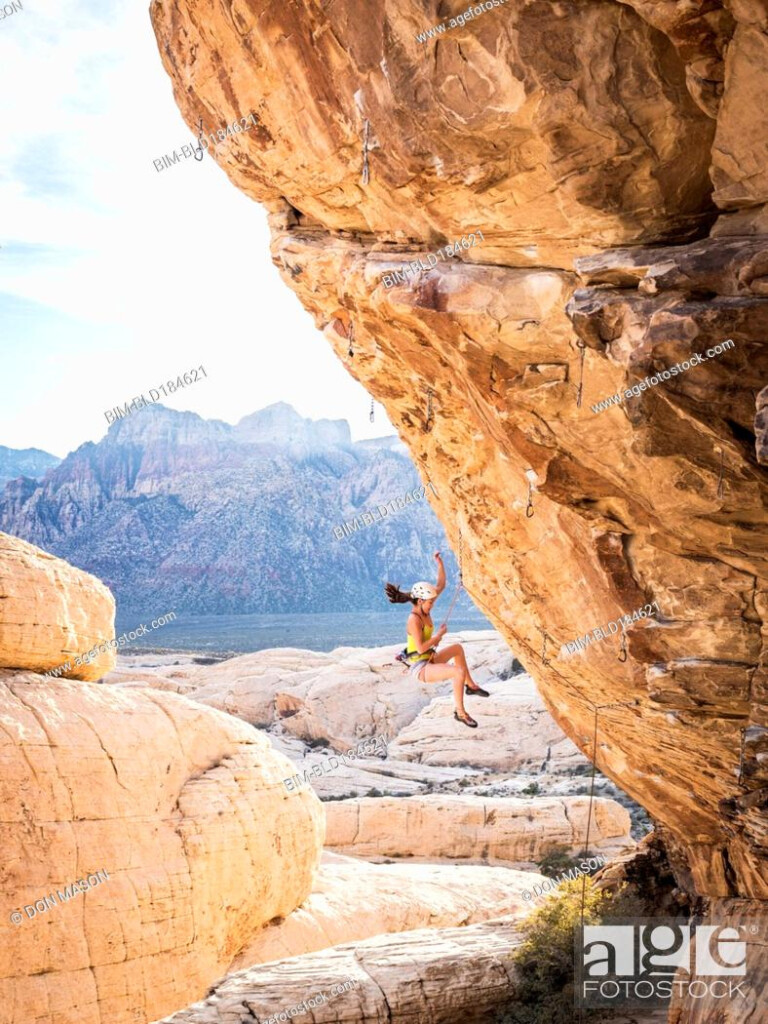 Mixed Race Girl Rock Climbing And Falling From Cliff Stock Photo 